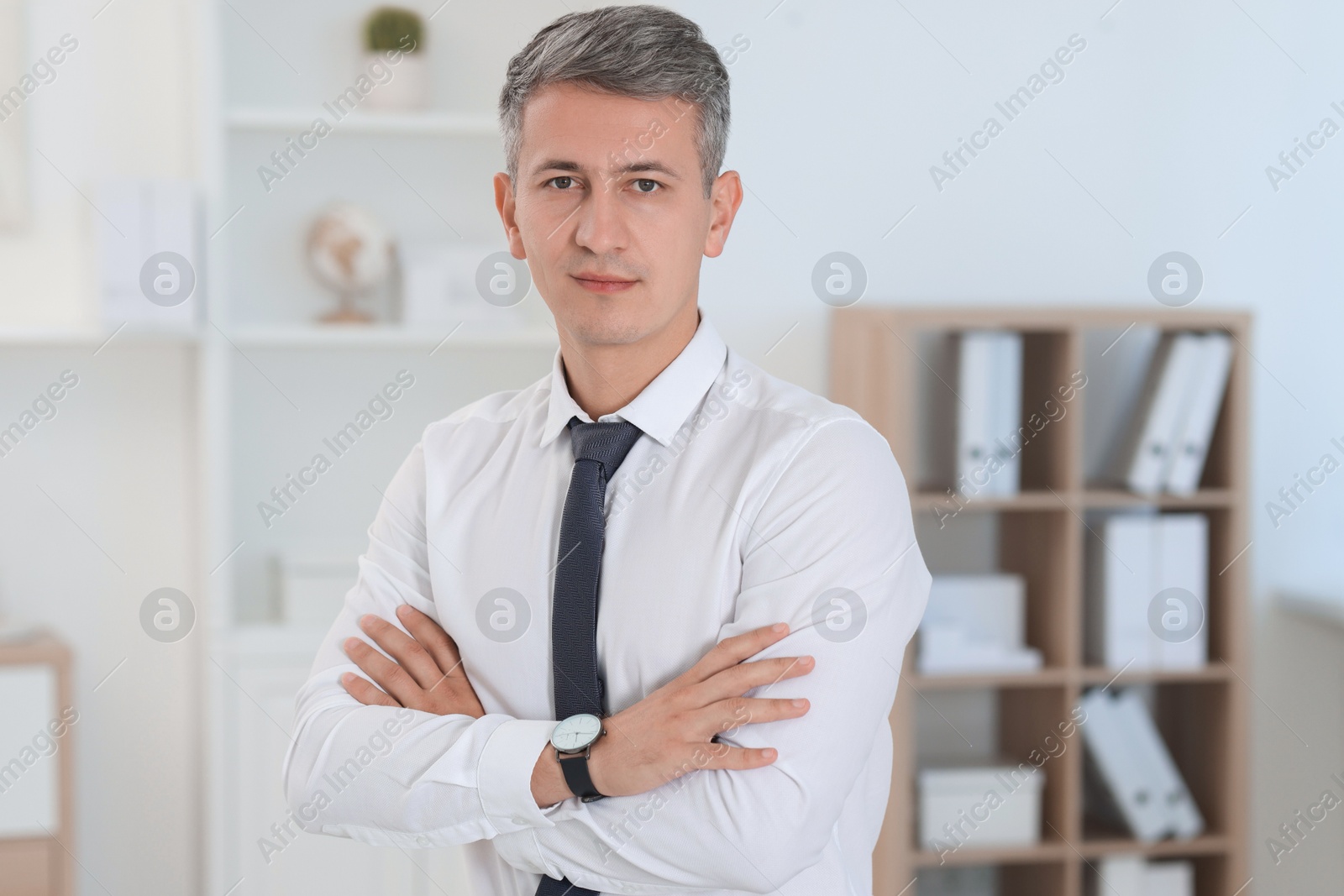 Photo of Portrait of businessman with crossed arms in office