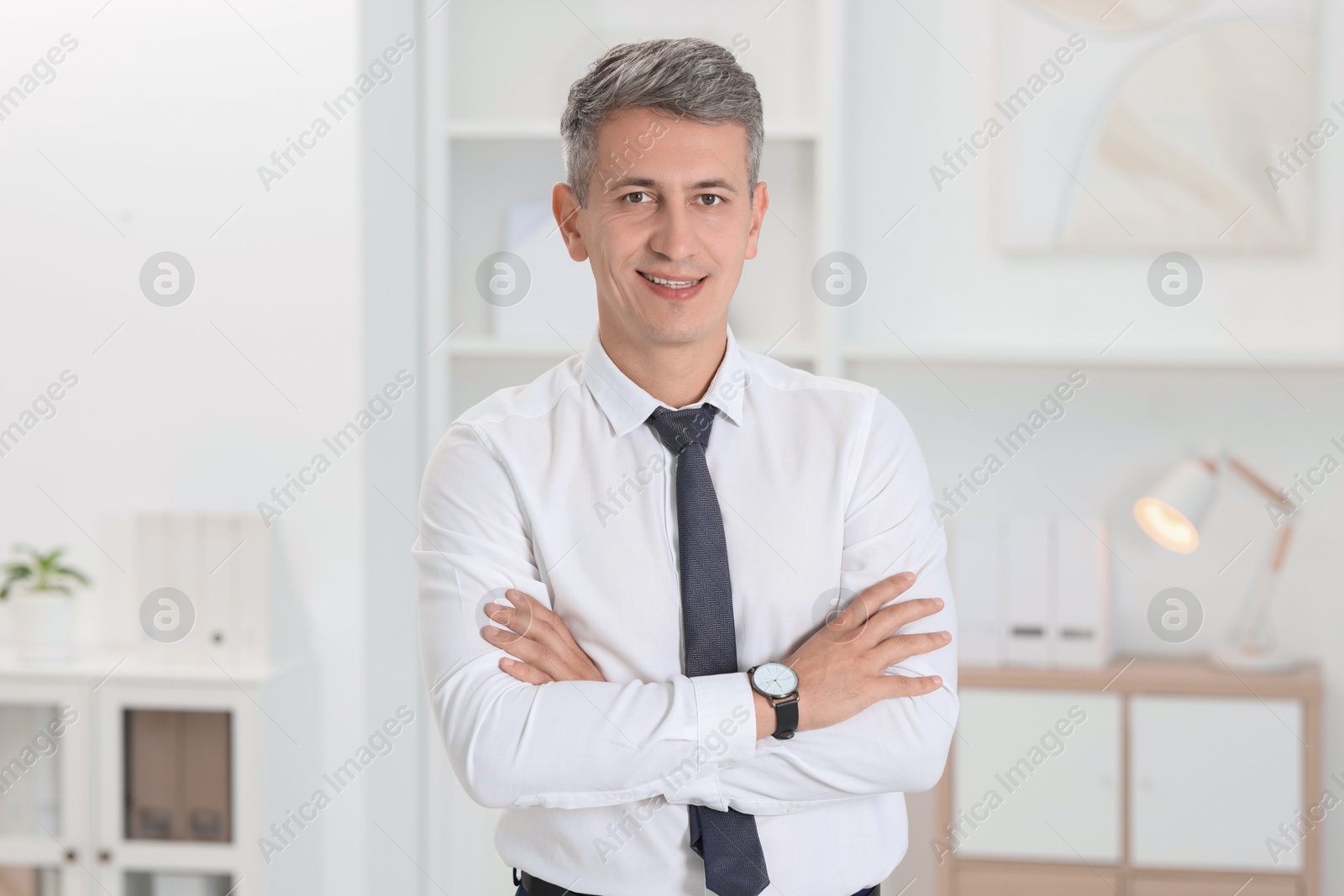 Photo of Portrait of businessman with crossed arms in office