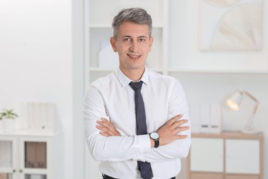 Portrait of businessman with crossed arms in office