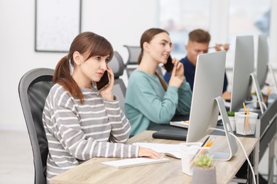 Photo of Sales department. People calling to clients in office, selective focus