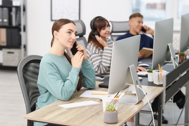 Photo of Sales department. People calling to clients in office, selective focus