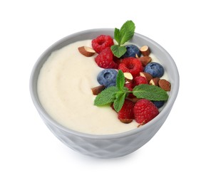 Photo of Tasty cooked semolina porridge with almonds, berries and mint isolated on white