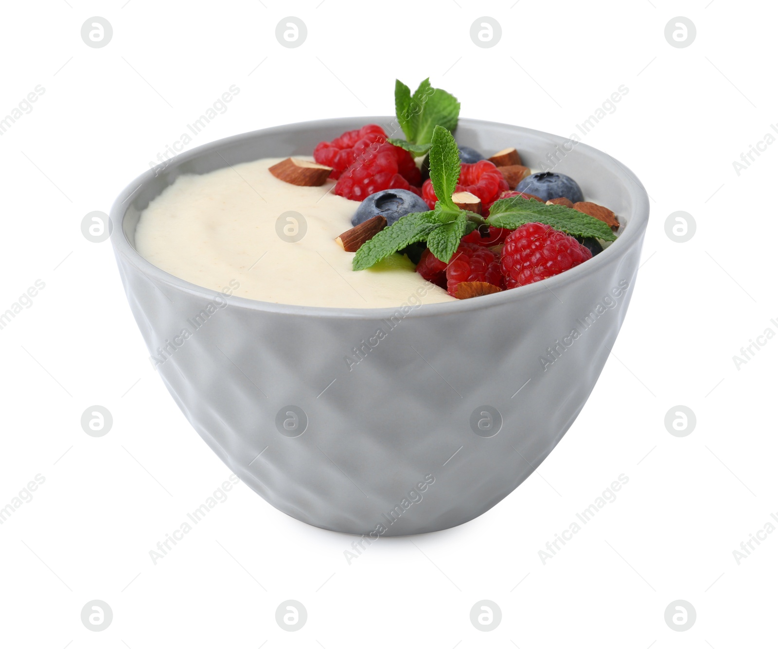 Photo of Tasty cooked semolina porridge with almonds, berries and mint isolated on white