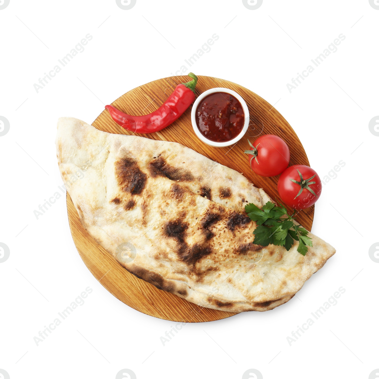 Photo of Delicious calzone with ketchup, fresh tomatoes and chili pepper isolated on white, top view