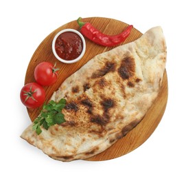 Photo of Delicious calzone with ketchup, fresh tomatoes and chili pepper isolated on white, top view