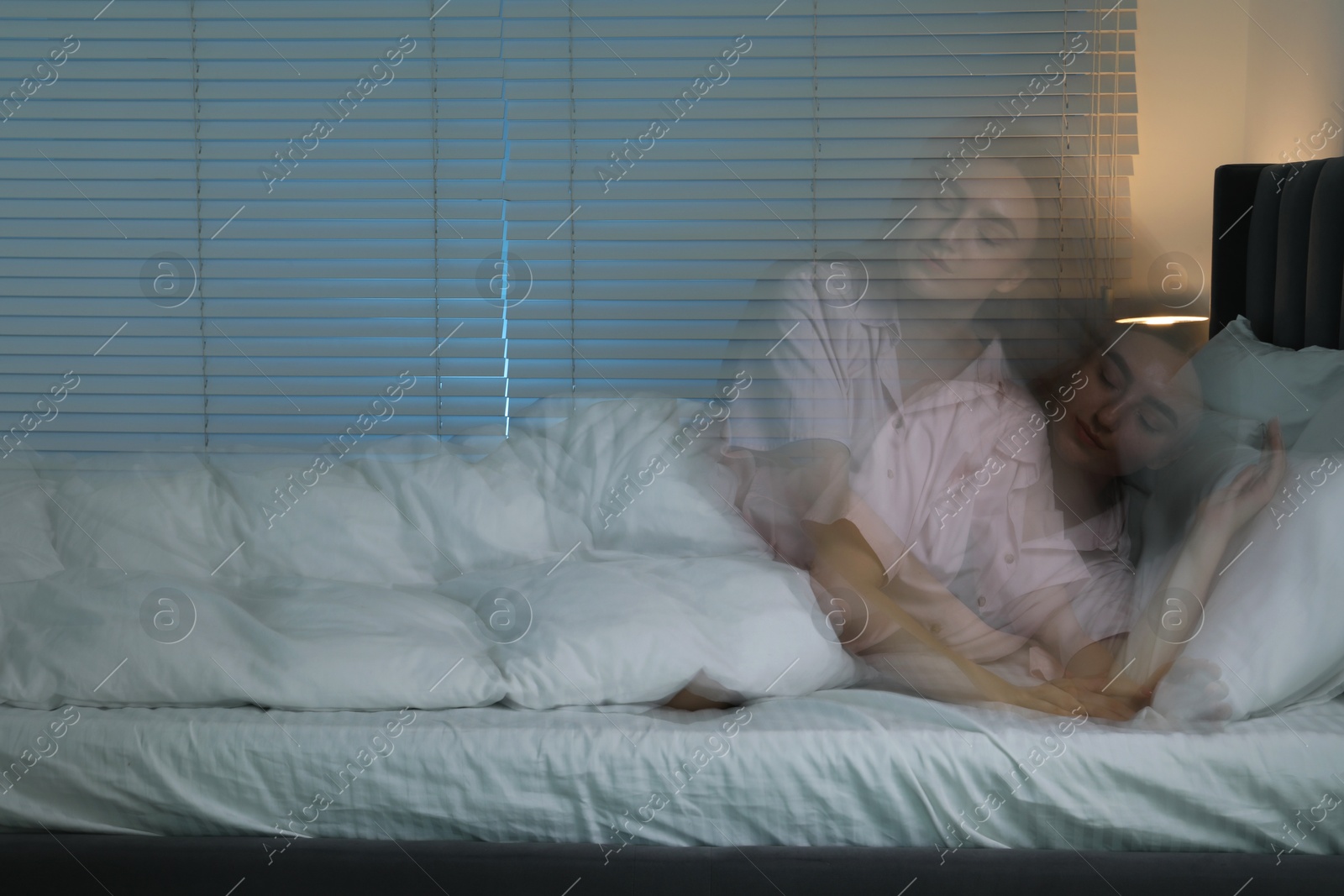 Photo of Young woman suffering from sleepwalking on bed at home, long-exposure