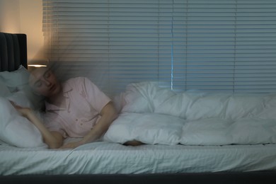 Photo of Young woman suffering from sleepwalking on bed at home, long-exposure