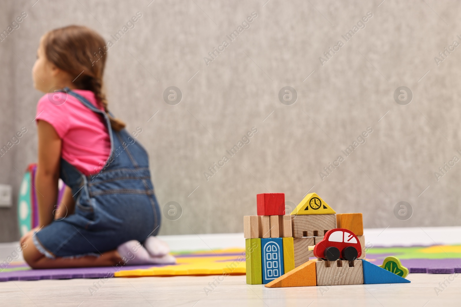 Photo of Autism therapy. Little girl sitting on floor in mental health center, selective focus. Space for text