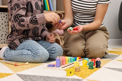 Photo of Autism therapy. Psychologist and little boy playing with educational toy indoors, closeup