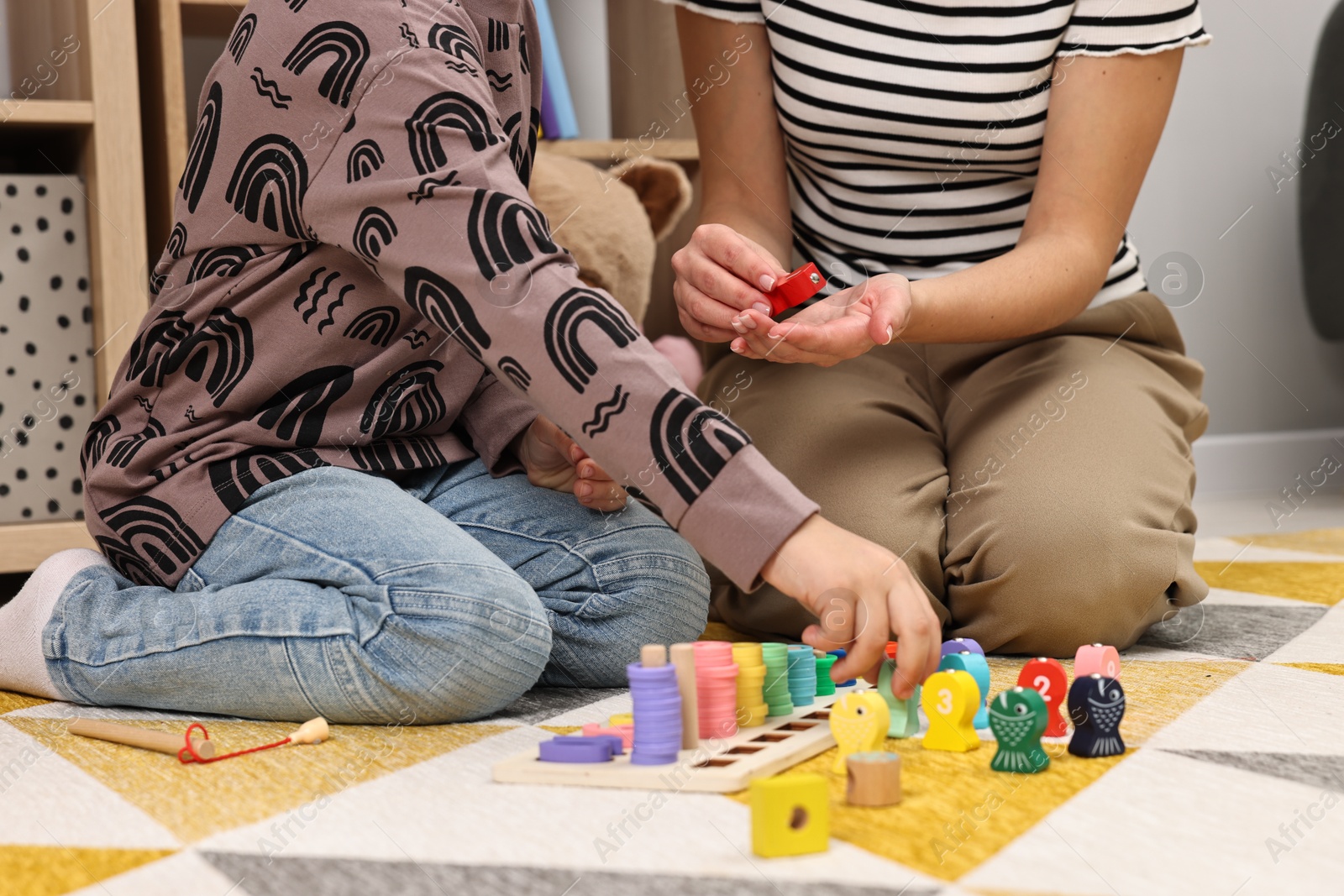 Photo of Autism therapy. Psychologist and little boy playing with educational toy indoors, closeup