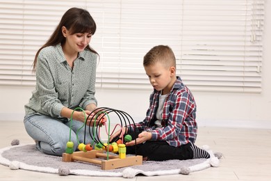 Photo of Autism therapy. Psychologist and little boy playing with educational toy in mental health center