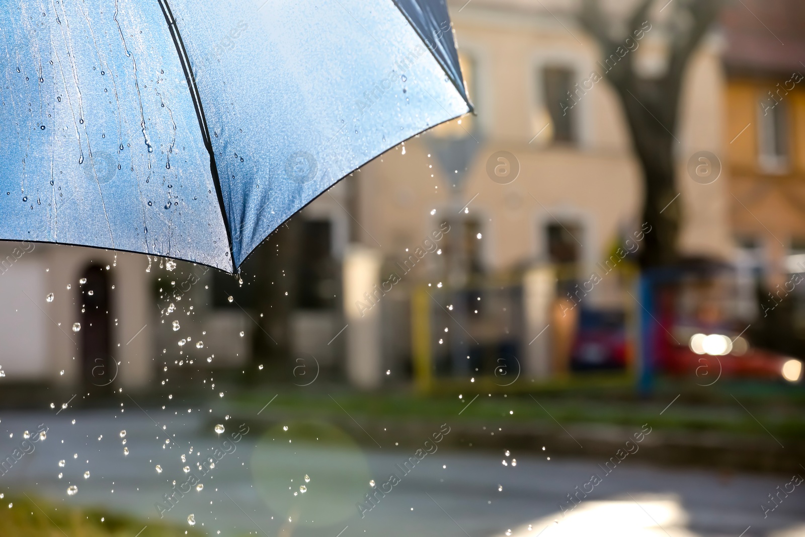 Photo of Open umbrella under pouring rain outdoors, closeup. Space for text