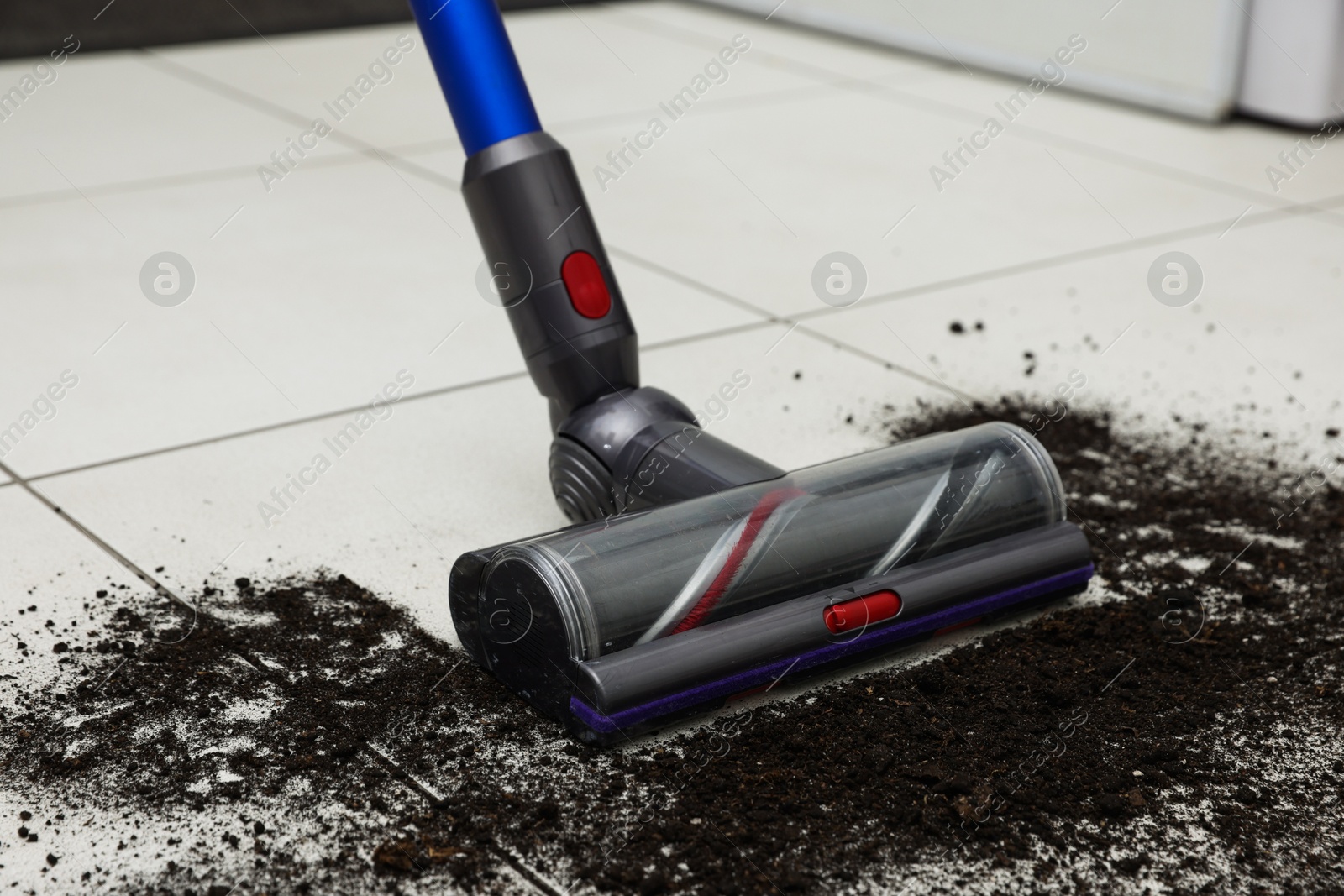 Photo of Cleaning floor with cordless vacuum cleaner indoors, closeup