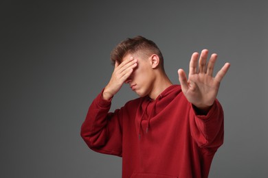 Photo of Portrait of scared young man on gray background, space for text