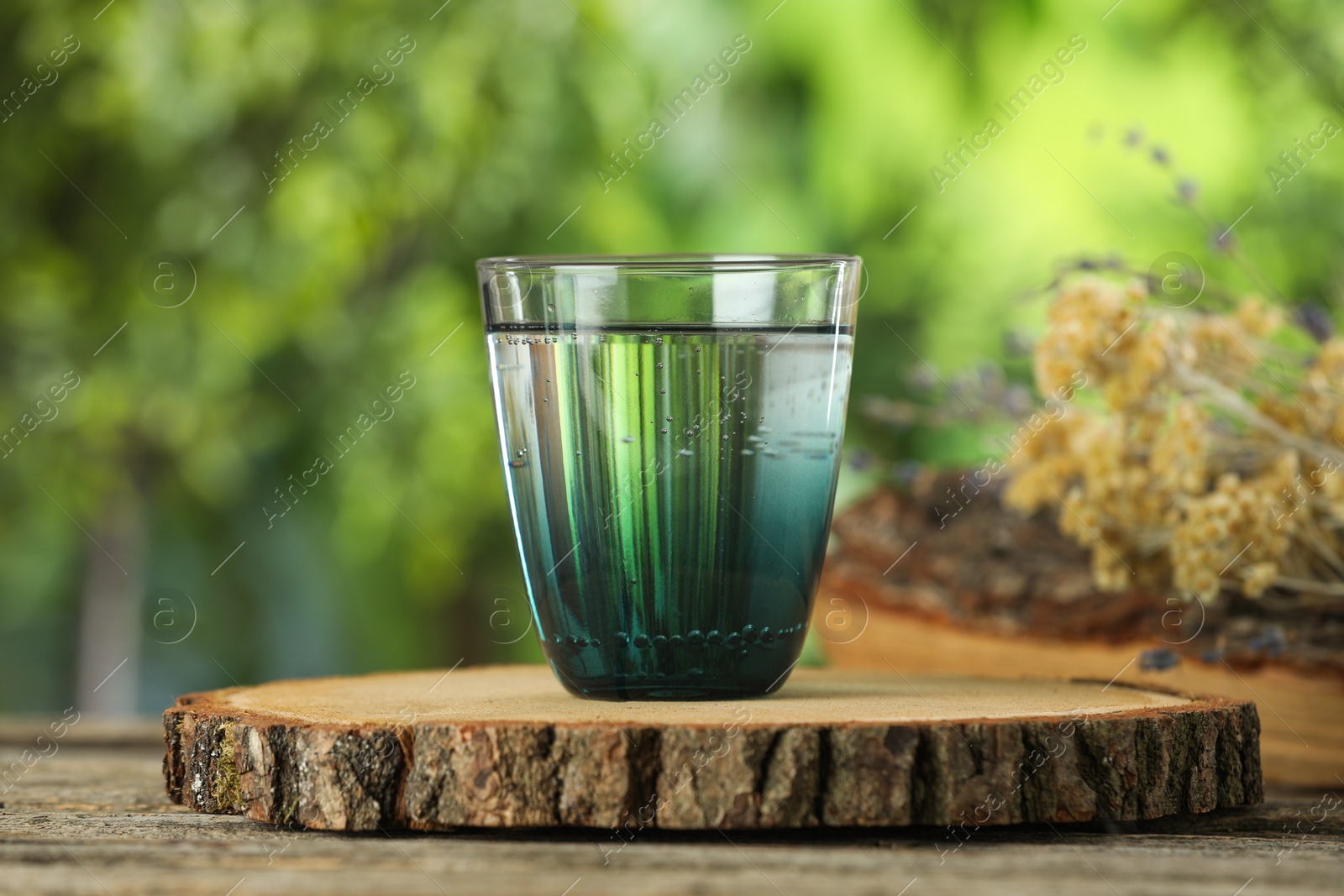 Photo of Soda water in glass on wooden table outdoors