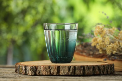 Photo of Soda water in glass on wooden table outdoors