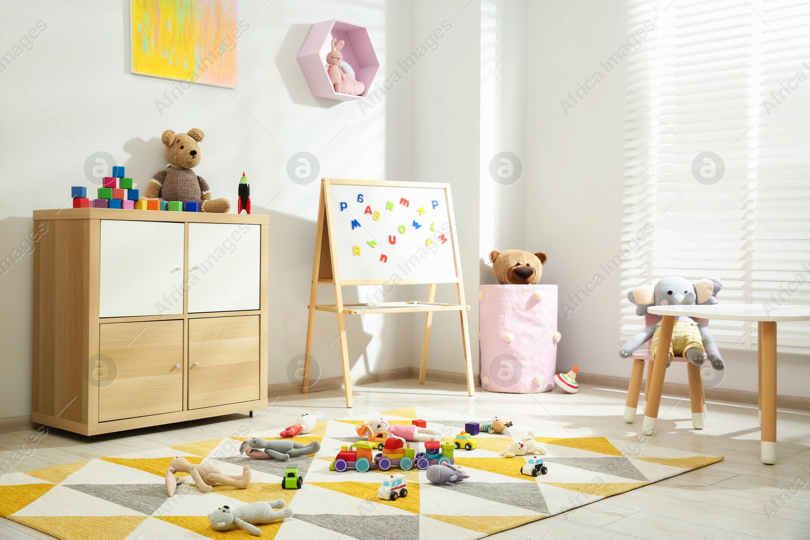 Photo of Beautiful child's room interior with toys and stylish furniture