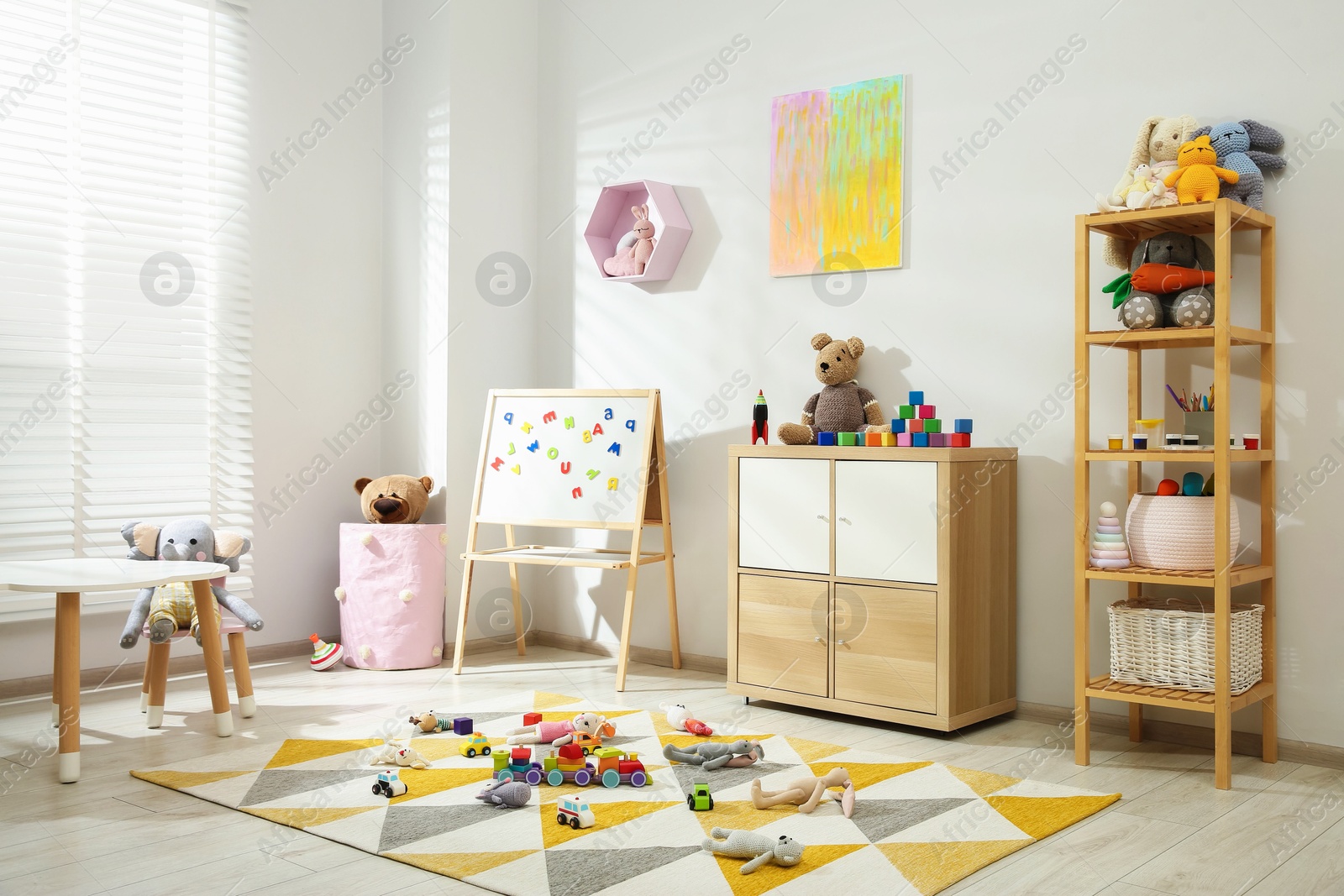 Photo of Beautiful child's room interior with toys and stylish furniture