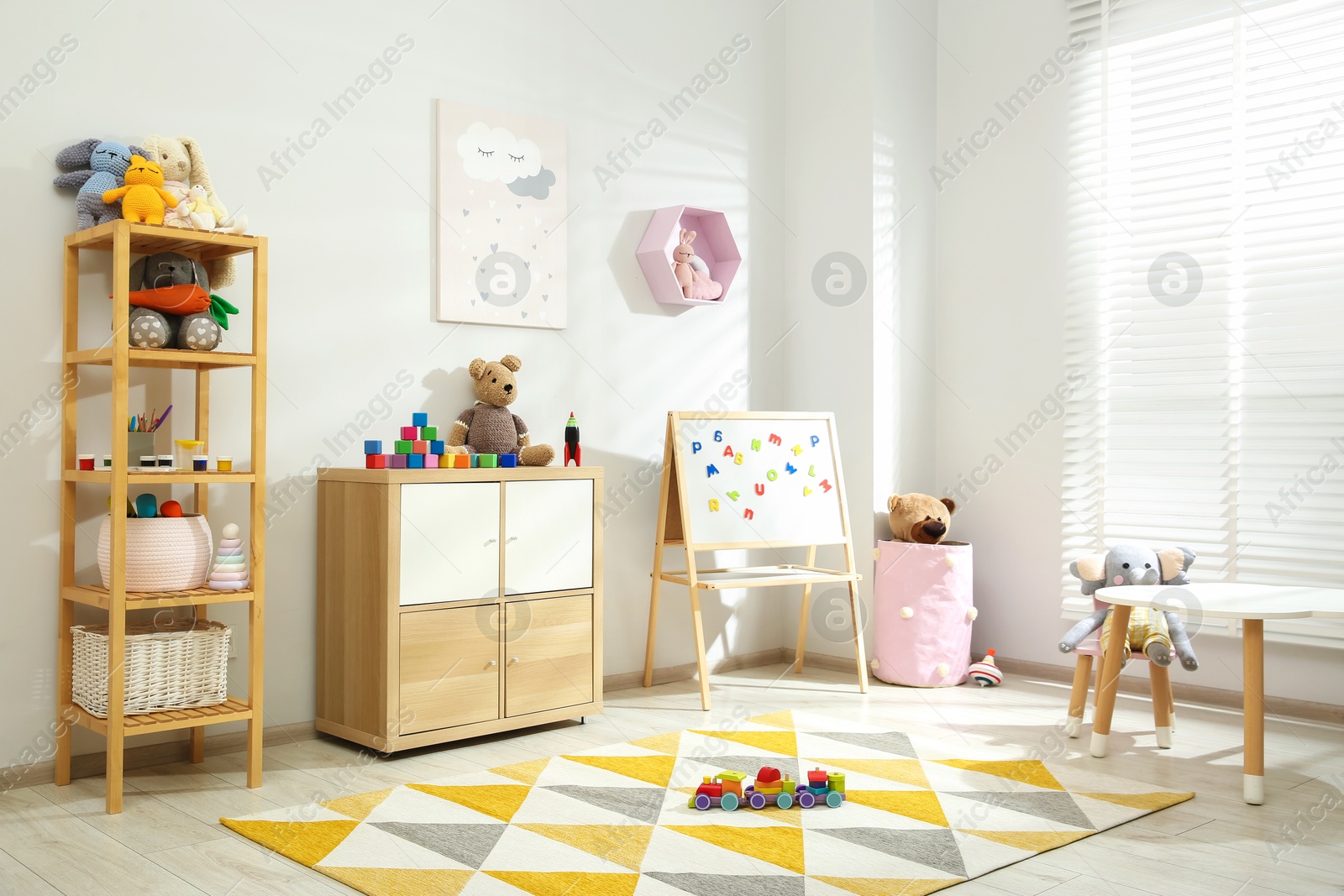 Photo of Beautiful child's room interior with toys and stylish furniture