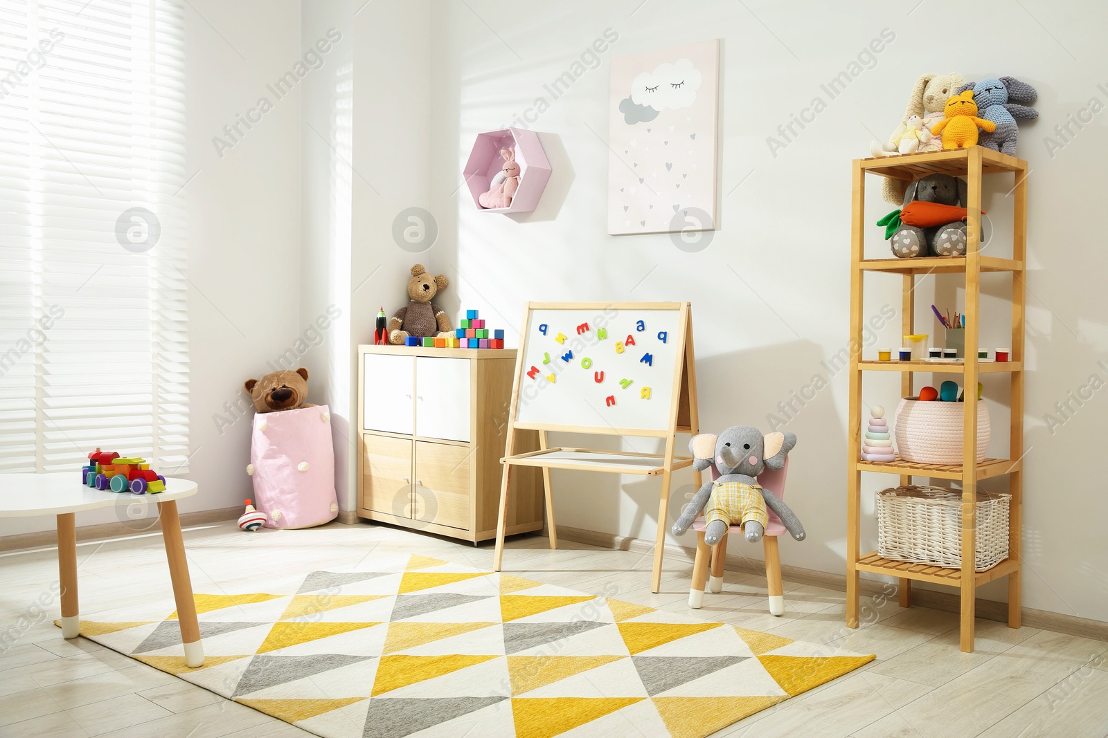 Photo of Beautiful child's room interior with toys and stylish furniture