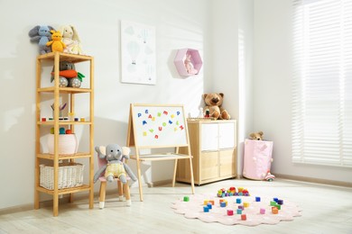 Photo of Beautiful child's room interior with toys and stylish furniture