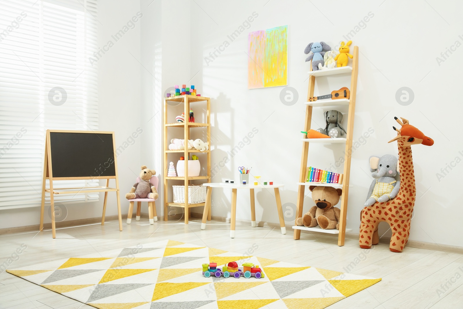 Photo of Beautiful child's room interior with toys and stylish furniture