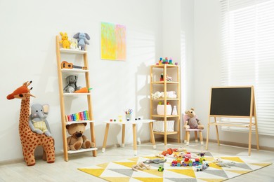 Photo of Beautiful child's room interior with toys and stylish furniture