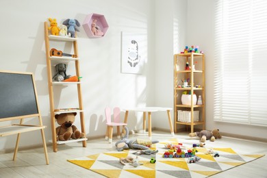 Photo of Beautiful child's room interior with toys and stylish furniture