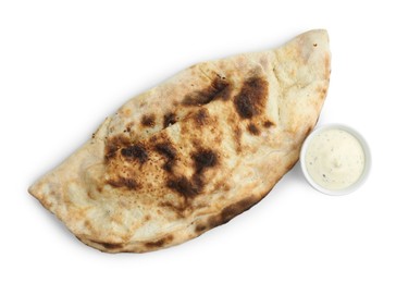 Photo of One delicious calzone with sauce isolated on white, top view