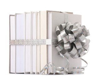 Photo of Books with silver bow as gift isolated on white