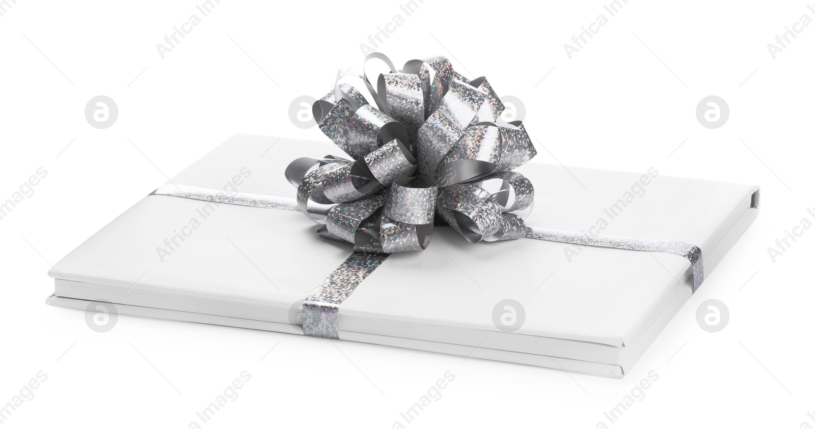 Photo of One book with silver bow as gift isolated on white