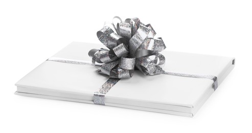 Photo of One book with silver bow as gift isolated on white