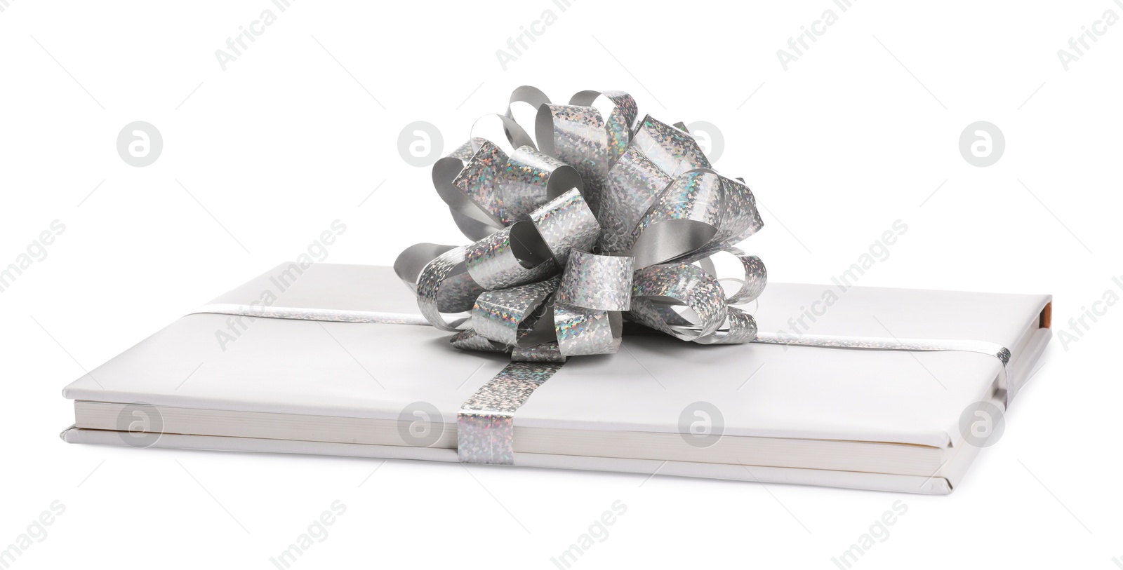 Photo of One book with silver bow as gift isolated on white