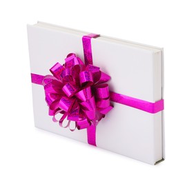 Photo of One book with purple bow as gift isolated on white