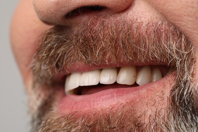 Photo of Smiling man with healthy teeth on light background, closeup view