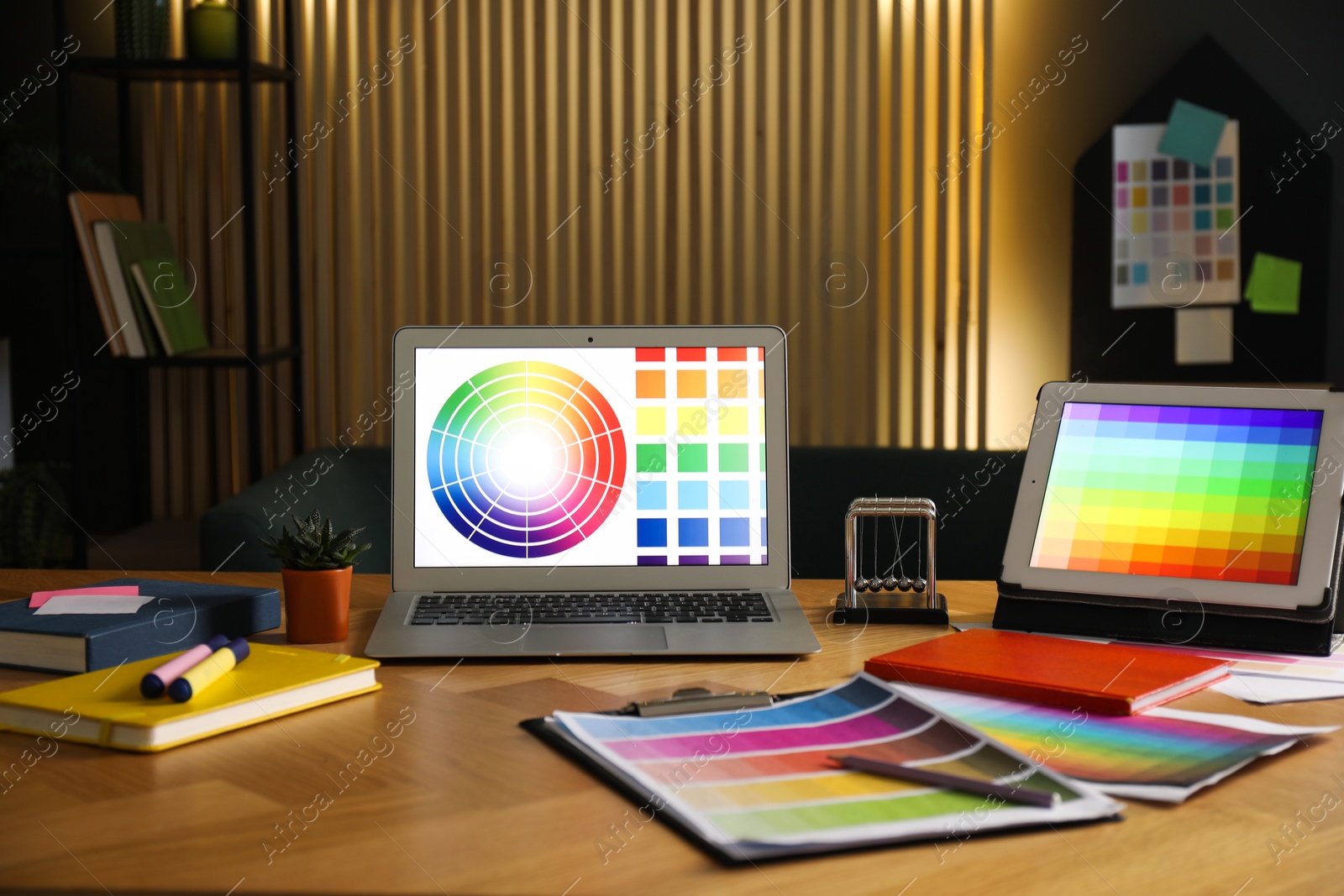 Photo of Designer's workplace with laptop, tablet, stationery and palettes on wooden table indoors