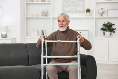 Photo of Senior man with walking frame on sofa at home