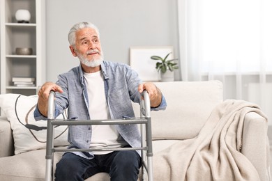 Photo of Senior man with walking frame on sofa at home