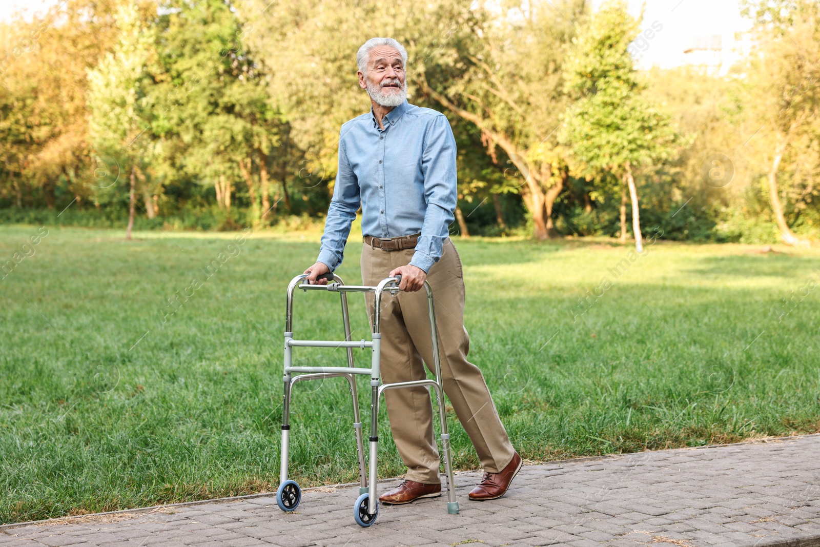 Photo of Senior man with walking frame in park