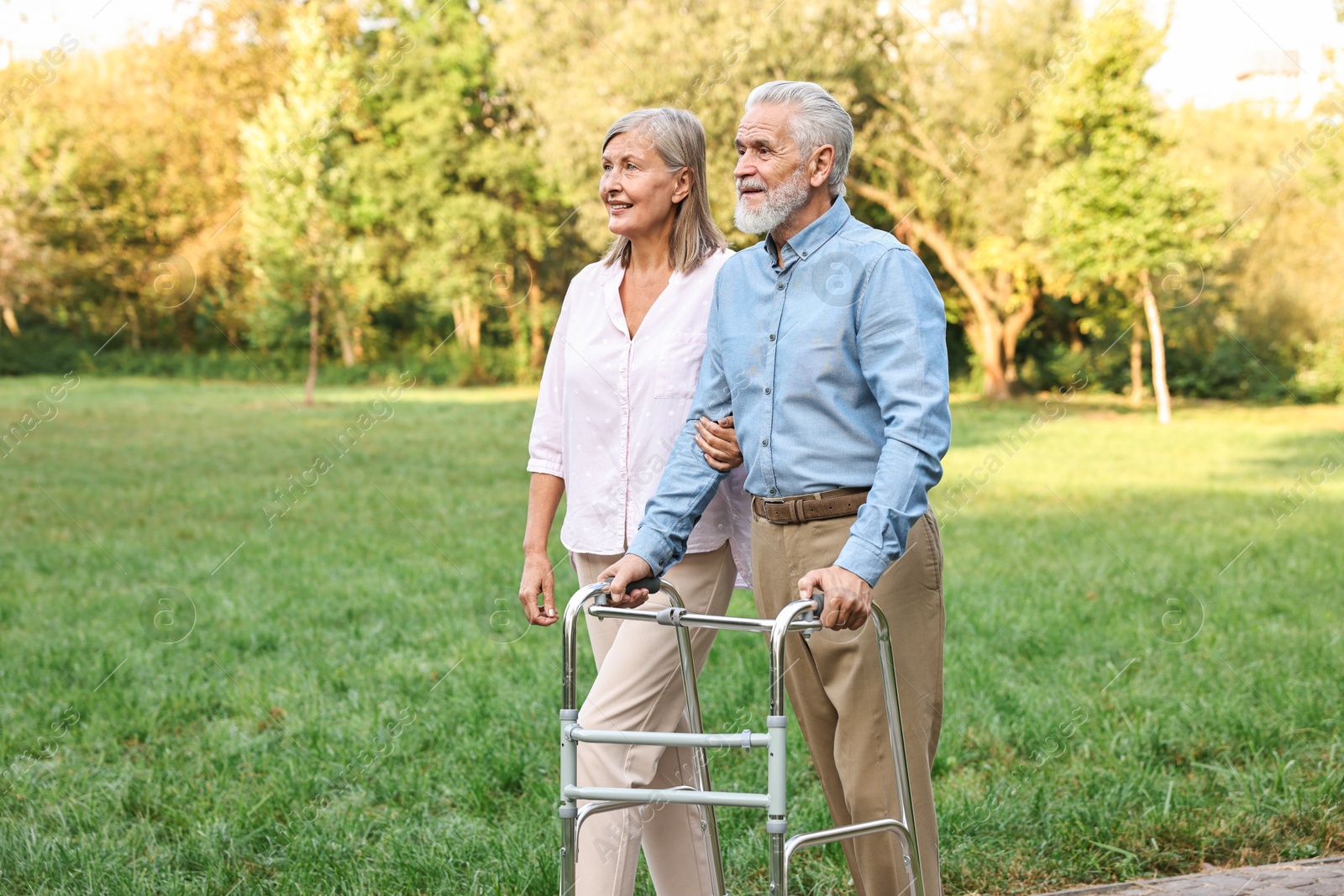 Photo of Senior couple with walking frame in park