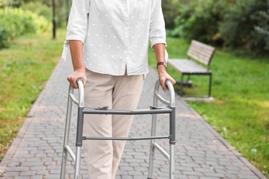 Photo of Senior woman with walking frame in park, closeup