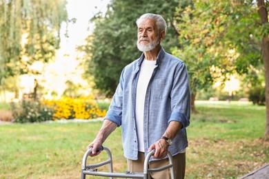 Photo of Senior man with walking frame in park