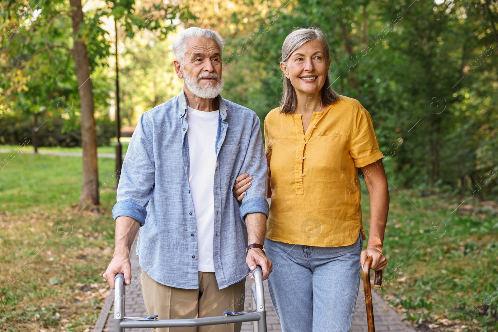 Photo of Senior couple with walking frame and cane in park