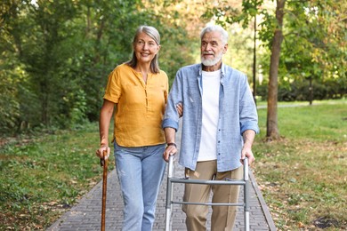 Photo of Senior couple with walking frame and cane in park