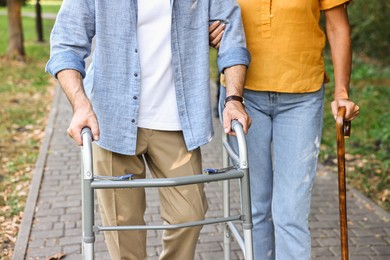 Photo of Senior couple with walking frame and cane in park, closeup