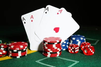 Poker chips, dices and playing cards on green table