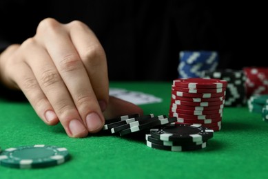 Woman with poker chips at green table, closeup