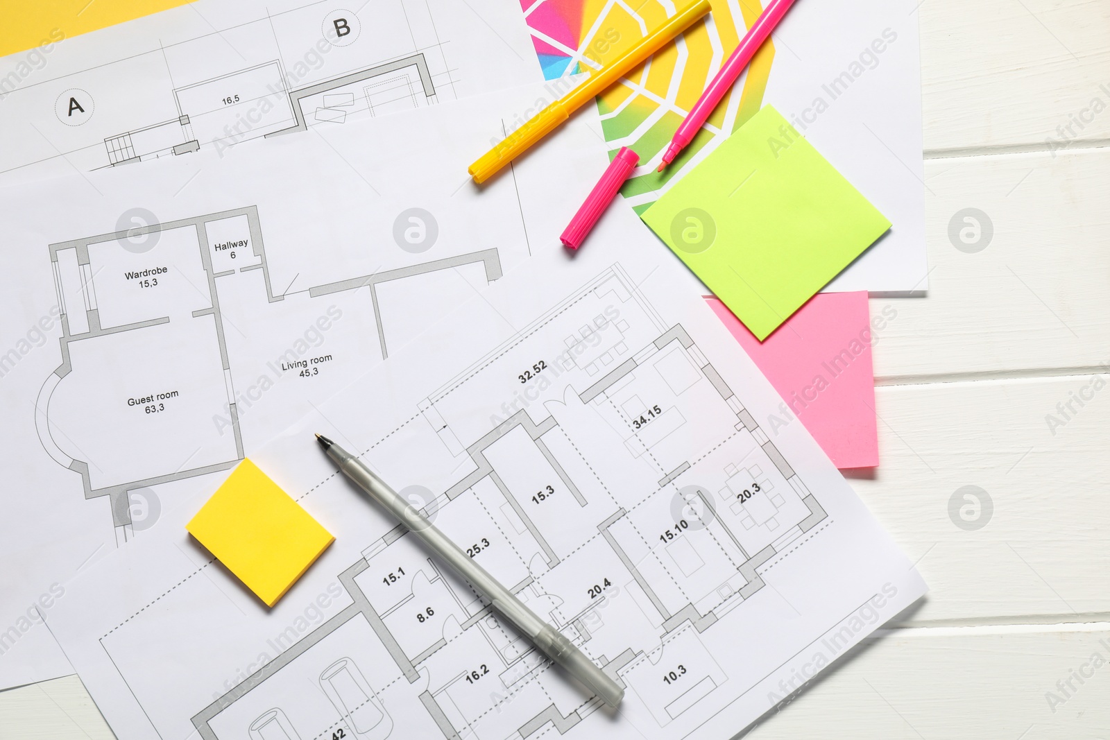 Photo of Designer's workplace with house plans, color palette and stationery on white wooden table, flat lay