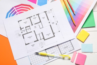 Photo of Designer's workplace with house plans, color palettes and stationery on white wooden table, flat lay