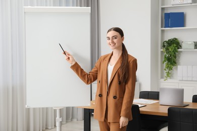 Photo of Happy woman near flip chart in office. Mockup for design